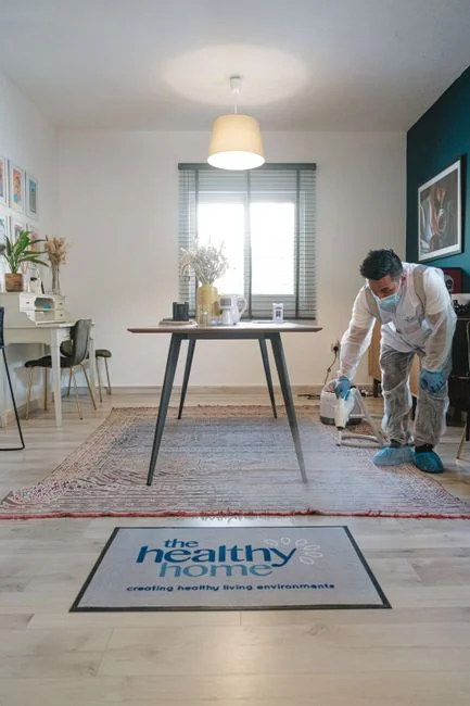 inventive Cleaner using a vacuum in a stylish indoor setting, showcasing cleaning equipment and techniques.